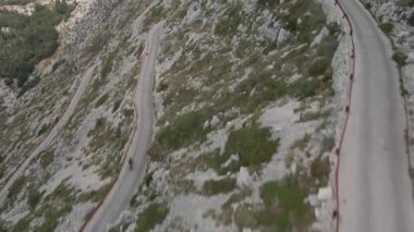 Bisikletçi, doğal park Biokovo Hırvatistan 'daki en yüksek dağın yamacı boyunca uzanan dar bir otobana indi..