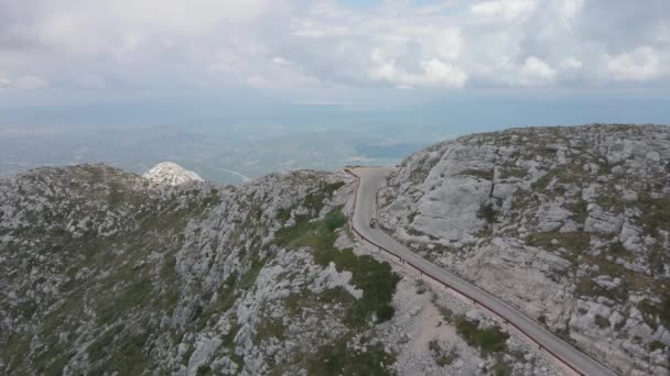 Due persone su uno scooter salire la tortuosa strada alpina al punto più alto di Biokovo in Croazia. — Video Stock