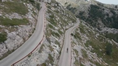 Bisikletçi Hırvatistan 'ın Biokovo Parkı' ndaki dar ve tehlikeli bir dağ yolunda ilerliyor.