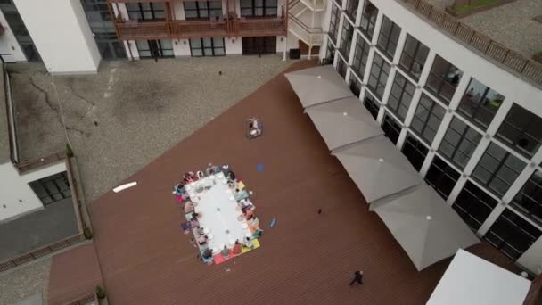 Flygfoto av en grupp kvinnor och barn engagerade i kreativitet på en träterrass i det fria. Målning. — Stockvideo