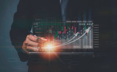 Ticari büyüme planlama ve strateji borsa ilerlemesi veya başarı fikri iş adamı tablet ekran yatırımında sanal hologram gramı grafiği gösteriyor