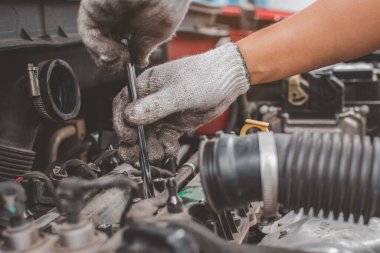 Araba tamircisinin elleri araba bakım, bakım ve servis konseptinde motor tamir anahtarı kullanır..