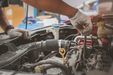 Tamircinin elleri motoru tamir etmek için İngiliz anahtarı kullanır. Araba tamir merkezi konsepti bakım, bakım ve araba bakım hizmetleri sunar..