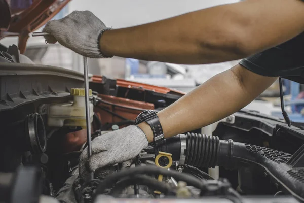 The mechanic uses his hand to turn the wrench to fix the engine. Concept of repair and service center for car maintenance, maintenance and repair services.