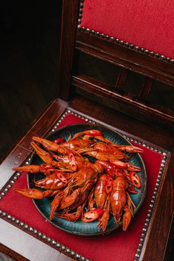 Barda sandalyede acı biberli haşlanmış kerevit.