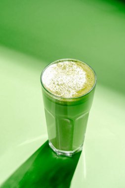 Yeşil arka planda kibrit latte. minimalizm biçimi
