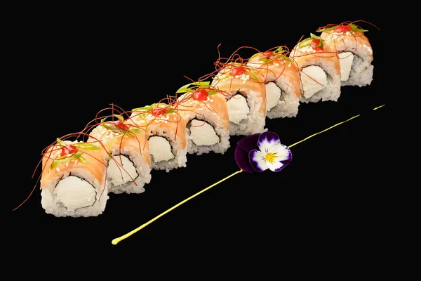 サーモンと日本の寿司ロール フィラデルフィアチーズ 日本のマヨネーズ シラチャソース チリスレッド 黒い背景に隔離され — ストック写真