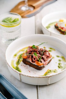 Smorrebrod, Danimarka usulü sandviç, kızarmış biftek, tatlı soğan ve vişneli domates.