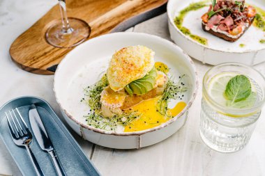 Haşlanmış yumurta ve holandez soslu avokado tostu.