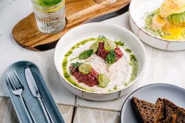 Yer mantarı soslu dana tartar ve salatalık turşusu, ekmek ve avokado tostu.