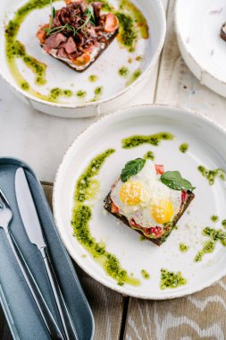 Smorrebrods, somon, yumurta, biftek, soğan, avokado ve kişniş soslu Danimarka sandviçi..