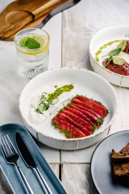 Gravlax, İskandinav kurutulmuş beyaz tabakta beyaz kremalı somon balığı. Üst görünüm