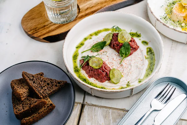 Yer mantarı soslu dana tartar, salatalık turşusu ve siyah ekmek.