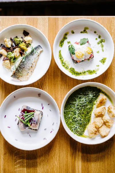 Somon, yumurta, ringa balığı, soğan ve sebzeli levrek ve pesto soslu gevrek karnabahar.