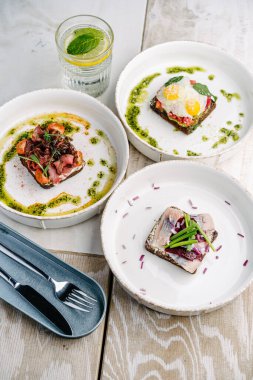 Smorrebrods, somon, yumurta, biftek, tatlı soğan, ringa, soğan, avokado ve kişniş soslu Danimarka sandviçi..