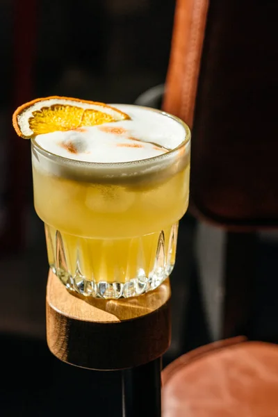 Alcoholic orange cocktail on the armrest of a chair. creative cocktail photo