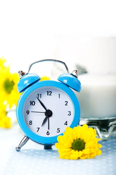 Blue alarm clock with milk — Stock Photo, Image