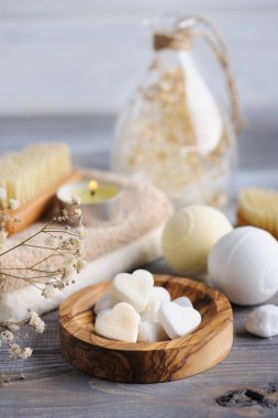 Kuru çiçekli banyo bombaları ve İskandinav tarzında mumlar. Beyaz beyaz bej renklerle süslenmiş, ahşap arka planda. Sonbahar natürmortu