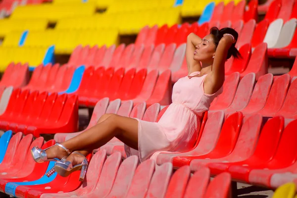 Modelo asiático posando no estádio sentado em assentos brilhantes — Fotografia de Stock