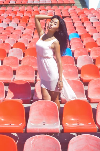 Aziatische model poseren in het stadion staande op de heldere zetels — Stockfoto