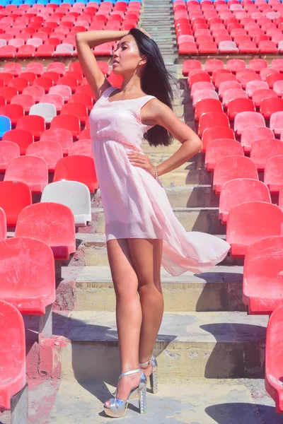 Asya model parlak koltuklarda stadyum ayakta, poz — Stok fotoğraf