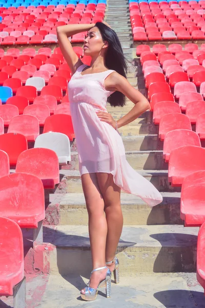 Retrato do modelo asiático posando no estádio em pé nos assentos brilhantes — Fotografia de Stock