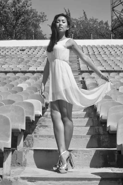 Modello asiatico In posa allo stadio in piedi sui sedili luminosi — Foto Stock