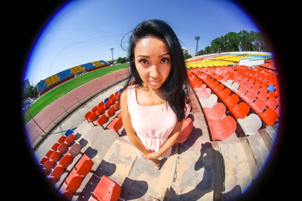 Portret van het Aziatische model poseren in het stadion staande op de heldere zetels — Stockfoto