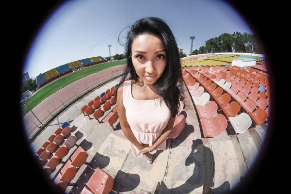 Portret van het Aziatische model poseren in het stadion staande op de heldere zetels — Stockfoto