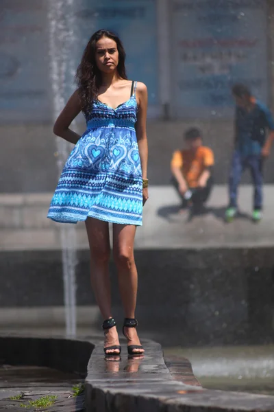 Fashionable woman in blue dress on the background of the fountain — Stock Photo, Image