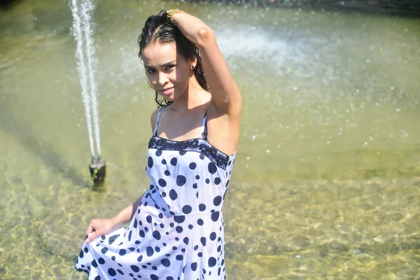 Gülümseyen kız ıslak elbise ve ıslak saç su çeşme, poz — Stok fotoğraf