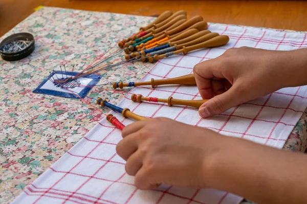 Hands of child making bobbin lace. Colorful lace threads. Skill and creativity.