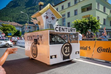 Aigle, Valais Canton, Switzerland -10 July, 2022: Passage of an advertising car of Century 21 brand real estate company in the caravan of the Tour de France in Switzerland. Sport event.