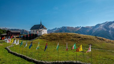 Kilise ve dağların manzarası. İsviçre Bettmeralp Kilisesi İsviçre kanton bayraklı. Sakin sahne.