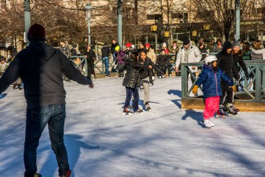 Çocuklar ve yetişkinler Stockholm, İsveç 'in merkezinde parkta paten kayıyorlar.