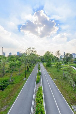 Kamu parkında akşam vakti güneş ışığının yansımasıyla bulutlar