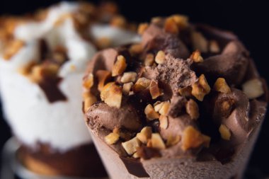 İki dondurma külahı, biri kremalı, diğeri de fındıklı ve bademli çikolatalı.