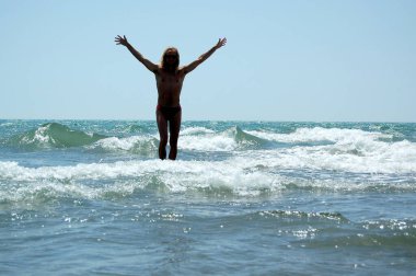 Man in the waves of the sea on a summer holiday