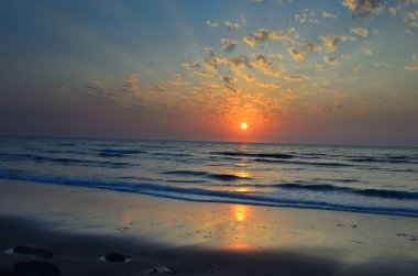 Parlak ışık gün batımından denize yayıldı.