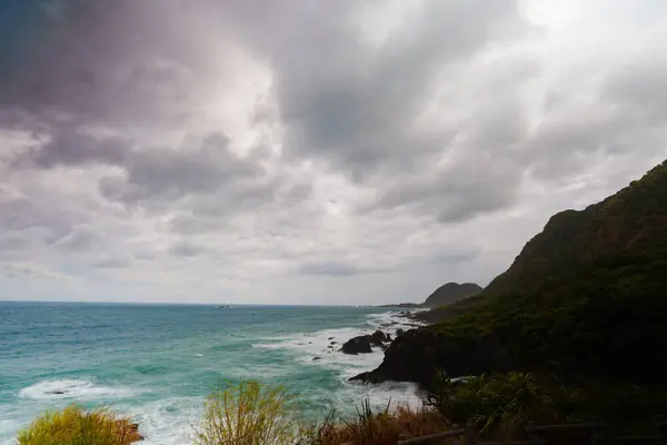Rüzgarlı dalgalar kara kayalıklara vurur.