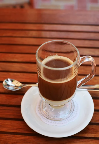 Glas koffie met melk in transparant glas op de tafel van een café — Stockfoto