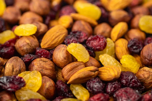 Mix of dried fruits. Healthy snacks. Almonds, raisins, hazelnuts, cranberries. Assorted nuts and dried berries. Selective focus, focus on the front. Healthy food concept. keto diet