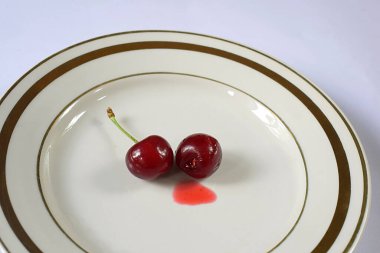 Tabağın ortasına iki kırmızı kiraz. Diyet gıda konsepti.