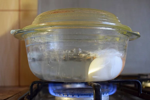 ガスストーブの上でガラス鍋に卵を沸かす — ストック写真
