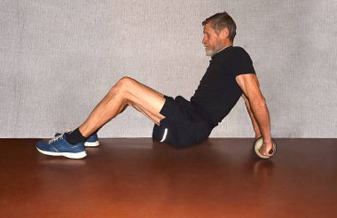 Erkek eller karın ve sırt kasları için egzersiz direksiyonunu tutar.