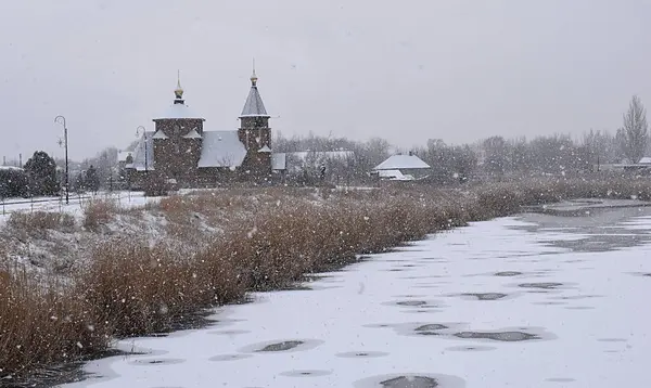 Paisaje Invernal Una Iglesia Orilla Del Río Durante Una Nevada —  Fotos de Stock