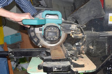 Bir adam testereyle tahtayı testereyle kesiyor..