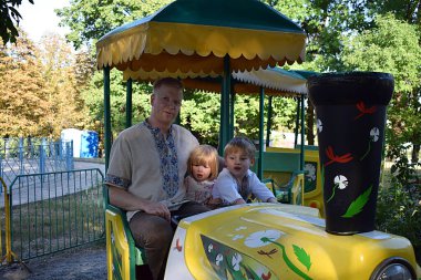 Parktaki atlıkarıncada küçük çocukları olan babam..