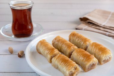Baklava ve Türk çayı. Beyaz bir tabakta çıtır şam fıstıklı baklava. Geleneksel Türk tatlıları.