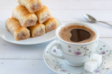 Kahvaltı için Türk usulü bir fincan köpüklü kahve ve bir tabak baklava..
